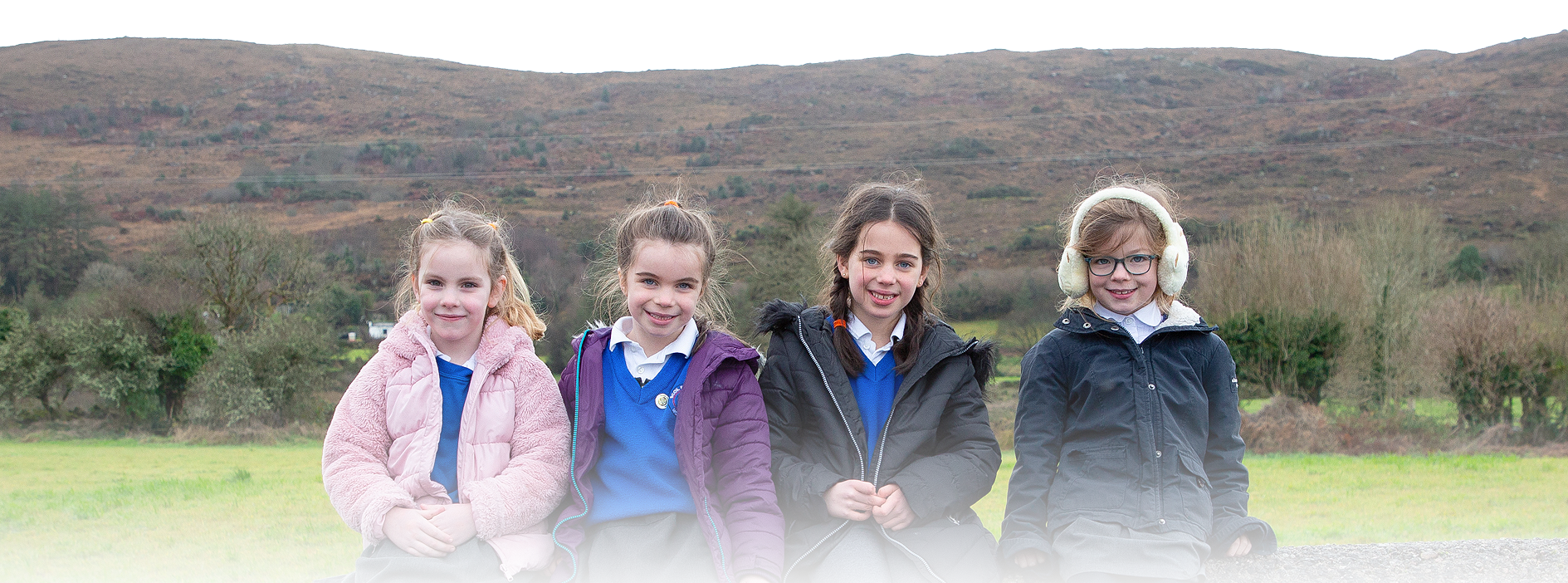 children sitting on wall together